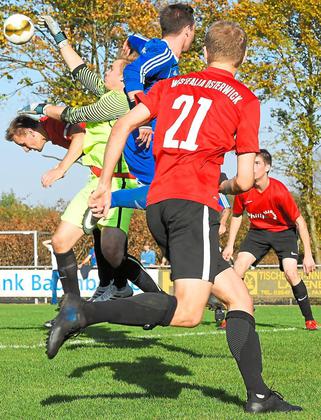Der Greifer: Florian „Flo“ Prause (2. von links), Torwächter aus Osterwick, boxt die Kugel aus dem eigenen Sechzehner. Tobias Paschert (1. von links), sein Mitstreiter, geht sogleich in Deckung. Foto: az